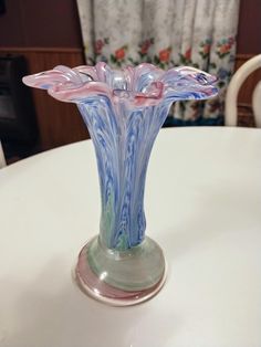 a glass vase sitting on top of a white table