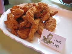 fried food on a plate with a sign that says frog legs in front of it