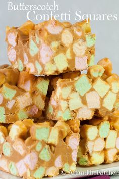 some kind of candy bar sitting on top of a white and purple plate with pink, green and yellow marshmallows