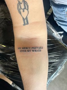 a person with a tattoo on their arm that says, my mercy prevais over my wrist