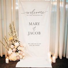 a welcome sign with flowers and candles in front of the entrance to a wedding ceremony