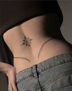 a woman's stomach with a small leaf tattoo on her lower back and side