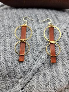 Genuine full-grain leather, laser cut rectangle shape earrings with gold colored stainless steel circles. Attached to 14k gold earring hooks. Approximately 2.5" by 1" Handmade  from the highest quality Horween leather from one of the oldest American tanneries, handcrafted to a luxurious finish. Minimalist Rectangular Leather Jewelry, Modern Brown Leather Earrings, Handmade Minimalist Leather Earrings, Brown Leather Minimalist Earrings, Minimalist Brown Leather Earrings, Everyday Gold Jewelry With Leather Strap, Gold Leather Dangle Earrings, Gold Leather Earrings For Gift, Everyday Brown Faux Leather Jewelry