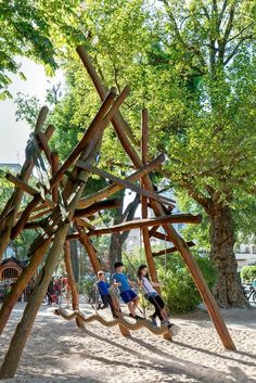 children playing on a wooden swing set in the park