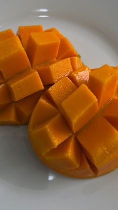 two pieces of mango sitting on top of a white plate