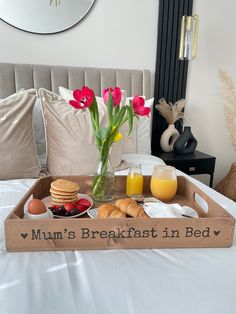 a tray with breakfast items on it sitting on a bed