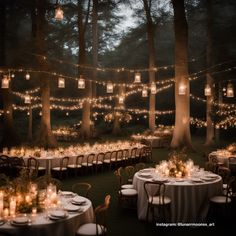 the tables are set with white linens and lit up lanterns in the woods at night