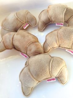 four stuffed animals sitting on top of a white counter next to each other with pink tags