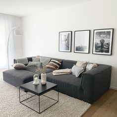 a living room filled with furniture and pictures hanging on the wall above it's coffee table