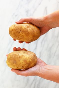 two hands holding potatoes in each other's palm