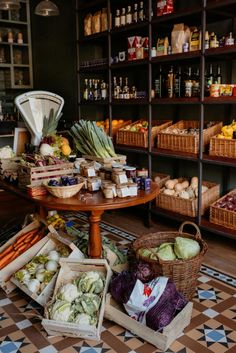 an assortment of fruits and vegetables in baskets on the floor next to shelves full of food