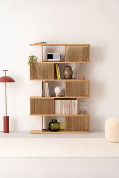 a book shelf with books on it and a lamp in the corner next to it