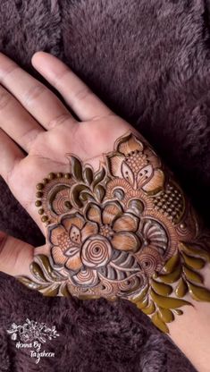 a woman's hand with henna tattoos on it