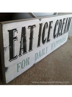 a wooden sign that says eat ice cream for daily happiness on the side of a wall