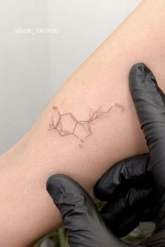 a tattoo on the leg of a person wearing gloves and holding a black glove in their hand