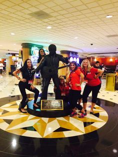 a group of people posing in front of a statue