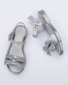 Meet the Mini Melissa Mar Sandal. This sweet sandal donned with a glittery bow appliqué is the ultimate fusion of comfort and cuteness for wherever your mini goes. With an adjustable buckle closure and Grenflex insole, she can wear these all day long without worrying about tired feet. Melissa Shoes, Bow Sandals, Mini Melissa, Jelly Sandals, Metal Buckles, Ballet Flats, Jelly, Buckle, Sandals