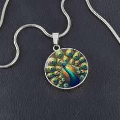 Admire the elegance of the Radiant Peacock Pendant Necklace, featuring a breathtaking stained glass style illustration of a peacock in full feather display. This intricate design showcases the peacock's vibrant plumage with stunning detail, capturing the essence of its regal beauty. Forged from premium surgical steel and available with a lavish 18k gold finish, this innovative jewelry boasts our exclusive design, handcrafted with care right here in the U.S.A by our dedicated team of skilled work Peacock Design Jewelry Gift, Peacock Design Jewelry For Gifts, Peacock Design Jewelry As Gift, Multicolor Peacock Design Jewelry Gift, Peacock Design Pendant Necklace Gift, Peacock Design Pendant Necklace As Gift, Round Peacock Design Jewelry Gift, Bohemian Peacock Necklace For Gift, Bohemian Peacock Necklace As Gift