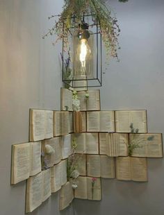 several open books are stacked on top of each other in front of a light fixture