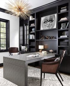 a modern office with black bookcases and leather chairs