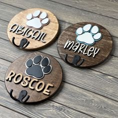 three personalized wooden coasters with dogs paw prints and name on the bottom one