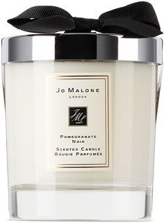 a white candle with a black bow on it's top and the words jo malone london written in cursive writing