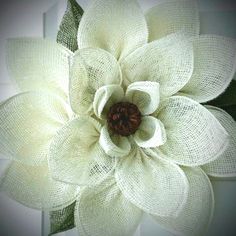 a large white flower with green leaves on it