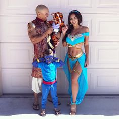 a man and woman in costume standing next to a child