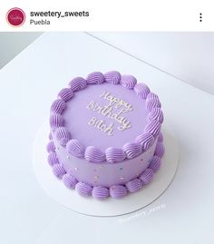 a birthday cake with purple frosting and happy birthday written on the top is sitting on a white table