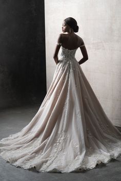 a woman in a wedding dress standing against a wall