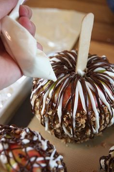 there are many different types of candys on the table and one is being dipped with chocolate