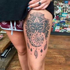 a woman's thigh with an owl tattoo on it