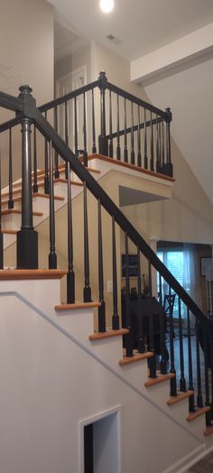 a staircase with black railing and wooden handrails