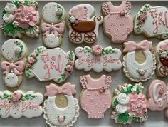 decorated baby cookies are arranged on a table