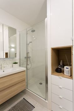 a bathroom with a shower, sink and mirror