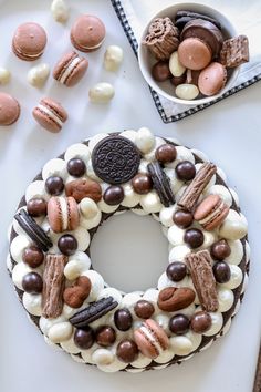 a cake decorated with cookies, marshmallows and oreos on a table