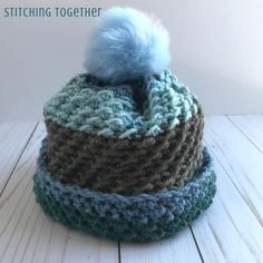 a crocheted hat with a blue pom - pom on top