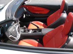 the interior of a sports car with red and black seats