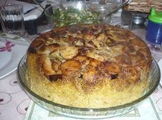 a large pie sitting on top of a glass platter next to plates and bowls