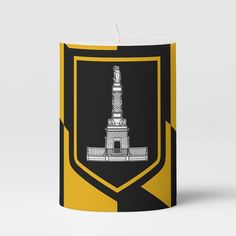 a black and yellow candle with a tower on it