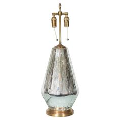 a silver and gold vase with two lights on it's side, against a white background