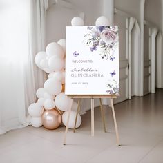 a welcome sign is next to balloons and a white banner with purple flowers on it