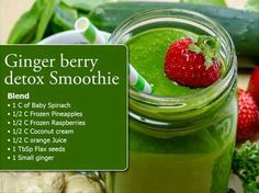 a green smoothie in a mason jar with strawberries