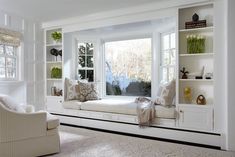 a living room filled with lots of white furniture