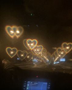 some lights are shining in the dark with hearts on them