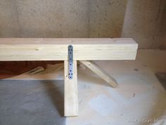 a wooden bench sitting on top of a cement floor