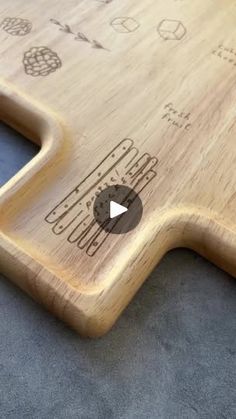 a wooden cutting board sitting on top of a blue carpeted floor next to a bottle opener