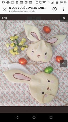 two ceramic rabbits sitting on top of a bed next to flowers and an orange ball