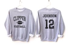 Customize this football shirt to meet your needs! Choose from short sleeve, long sleeve, hoodies, and crewneck sweatshirts and add your team/mascot and name/number! Other color options and styles are available. If you don't see what you're looking for send us a message! The shirts are a UNISEX retail fit - they are more of a relaxed fit and may run a little large on women and those with a smaller frame. Make sure to see the size and fit charts (last images) to confirm the best fit for you. We re Long Sleeve Tops For Sports Events, Long Sleeve Sports Fan T-shirt For Sports Season, Team-colored Long Sleeve Sweatshirt For Football Season, School Spirit Long Sleeve Tops For Football Season, Football Season Sports Fan Long Sleeve Hoodie, Long Sleeve Team T-shirt For Football Season, Sports Fan Long Sleeve Hoodie For Football Season, Long Sleeve Sports Fan Hoodie For Football Season, Long Sleeve Tops For Football Season Fan Merchandise