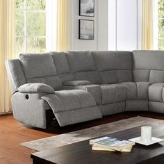 a living room with a large gray sectional couch and coffee table in front of it